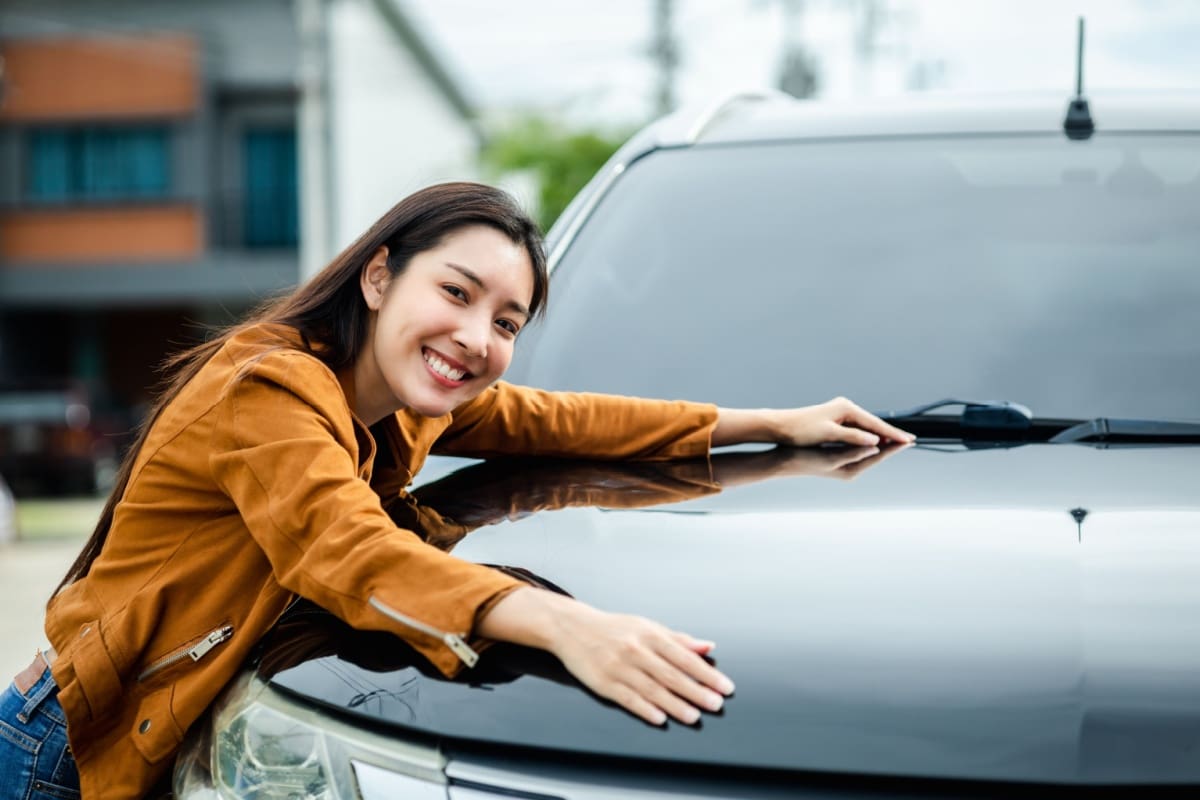 Woman enjoying her new car insured with liability insurance