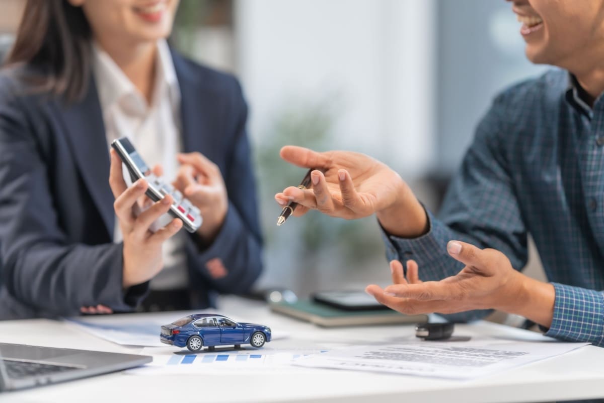 Insurance agent and customer discussing auto insurance rates.